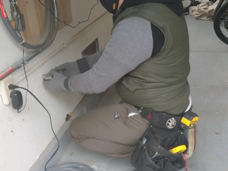 Electrician performing outlet wiring in a Elizabethtown garage